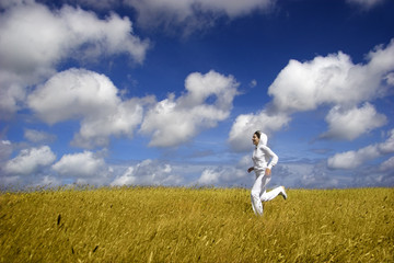 Bautiful woman running on a golden meadow