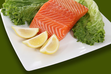 Salmon marinating on a dish with garnishments