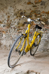 Fototapeta na wymiar Old yellow bike on the wall