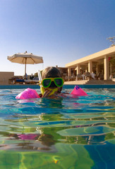 Girl in swimming pool of tropical resort hotel