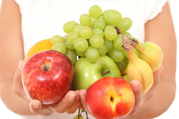 fresh fruits in hands on white