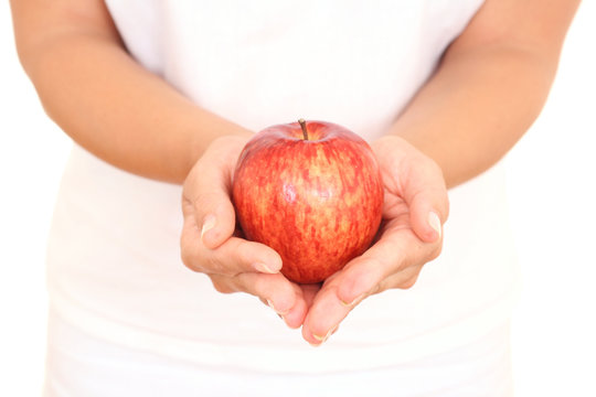 red apple in hands on white