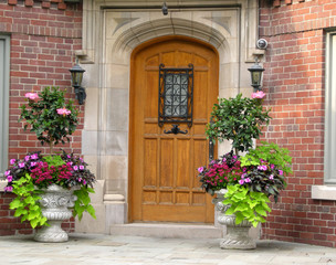 elegant house entrance with oak door and flower pots