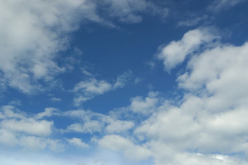 Blue sky and fluffy white clouds background.