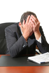 Frustrated business man hold his head in his hands.