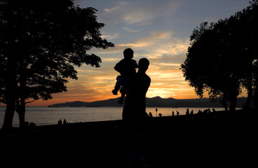 Obraz na płótnie Canvas father and sun silhouette shot at sunset