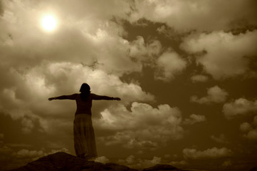 woman with arms wide open at the coast in sepia