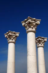 Fotobehang Three ancient greek pillars against a blue sky © Fyle