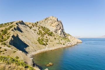 Fototapeta na wymiar Rocky coast of the black sea. A wild beach under mountain