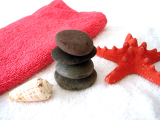 Spa essentials (pyramid of stones with white towel and seashell)