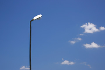 Lamppost against the blue sky with clouds