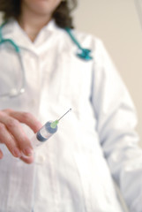 Docator holding with one hand a medical syringe