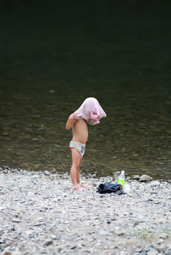 Child Changing Clothes After A Bath In The River