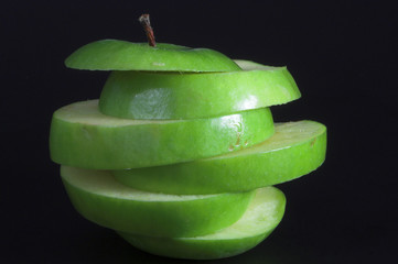 A sliced green apple in a stack.