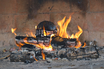 Flame of a fire and fire wood in fireplace