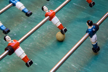 Detail of foosball table with toy players and yellow ball