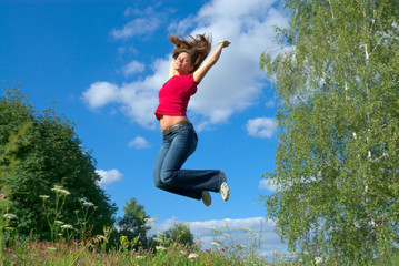 Beautiful lady jumping in summer landscape