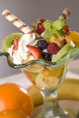 mixed fruit with cream in glass close up