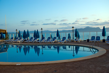 Fototapeta na wymiar blue pool in the hotel sunset