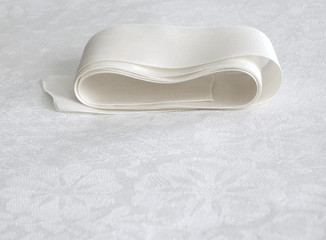 White satin ribbon on old cotton cloth