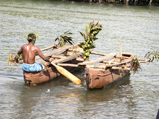 Melanesian in wooden outrigger canoe - obrazy, fototapety, plakaty