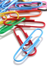 Colorful paperclips, scattered on white background 