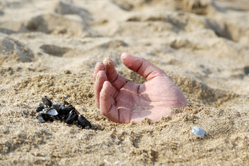 main dans le sable