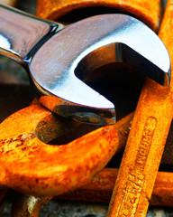 Shiny new spanner with rusty old spanners.