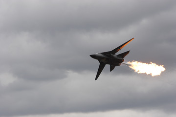 Front line jet fighter in the air doing a fuel dump and flame
