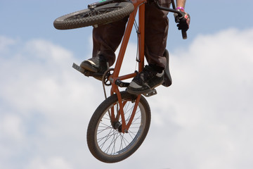 A BMX (Bicycle Moto-cross(X)) in the air against the sky