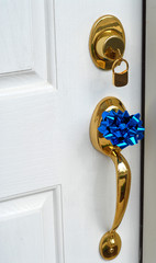 Lock and handle on door of new home with a bow on the handle