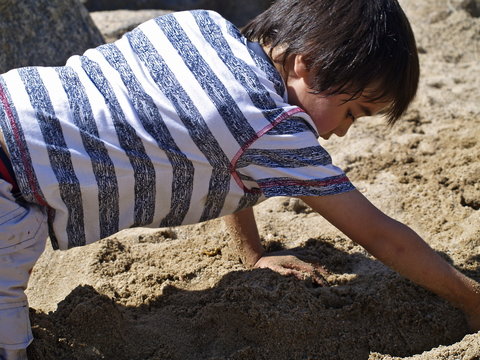 jungen spielt im sand mit wasser
