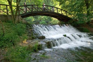 wooden bring over small waterfall