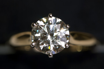 A very large diamond ring on a black background.