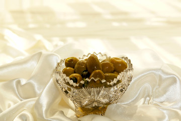Juicy green olives in a cut glass crystal