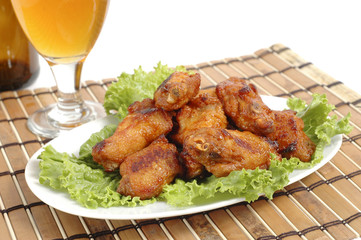 Plate of delicious barbecued wings on bed of lettuce.