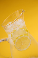 Jug of iced water on yellow 