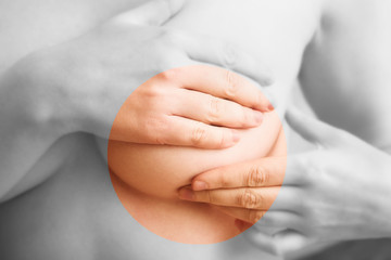 Woman examining her breast for signs of breast cancer 