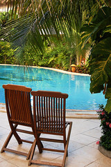 two wooden chairs at the poolside