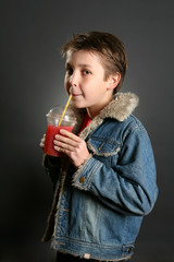 A young boy sips a healthy berry juice.