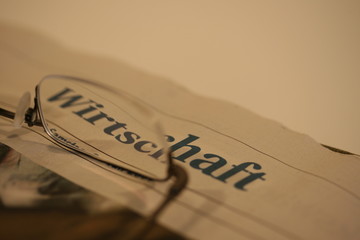 Wirtschaftszeitung und Brillenglas