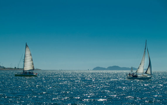 sailing ships with sun behind