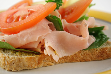 Ham lettuce tomato and cheese open sandwich on wholemeal bread.