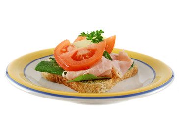 Ham lettuce tomato and cheese open sandwich on wholemeal bread.