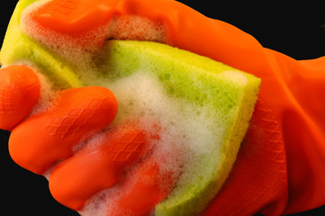Sponge held by a hand in an orange protective glove