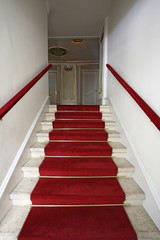white upstairs and red velvet carpet