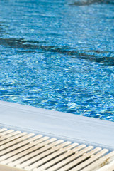 Obraz premium Pool edge fragment with grill and blue water