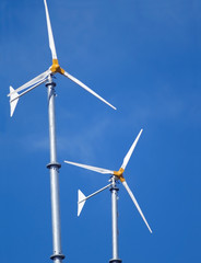 Two small wind turbines against a blue sky