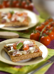 toast bread with ham cheese tomato and basil close up
