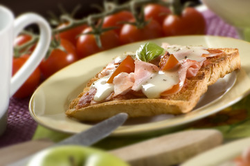 toast bread with ham cheese tomato and basil close up